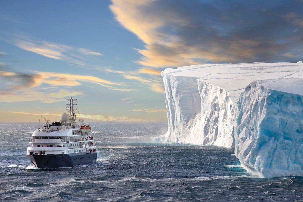 Kreuzfahrtschiff an einem riesigen Eisberg.