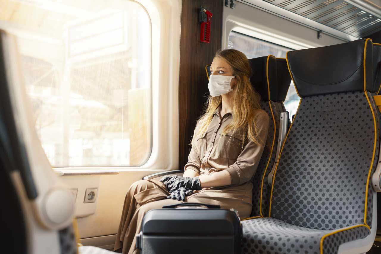 Frau mit Maske im Zugabteil
